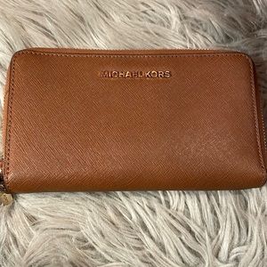 Michael kors brown wallet. Never used and has strap.